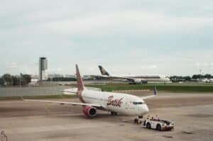 Two airplanes at an airport, showcasing commercial aviation on the tarmac.