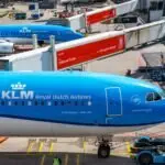 KLM Royal Dutch Airlines planes at airport gate, bustling aircraft activity.