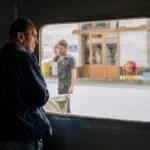 Adult man looking out a ferry window in İstanbul, capturing the city's bustling ambiance.
